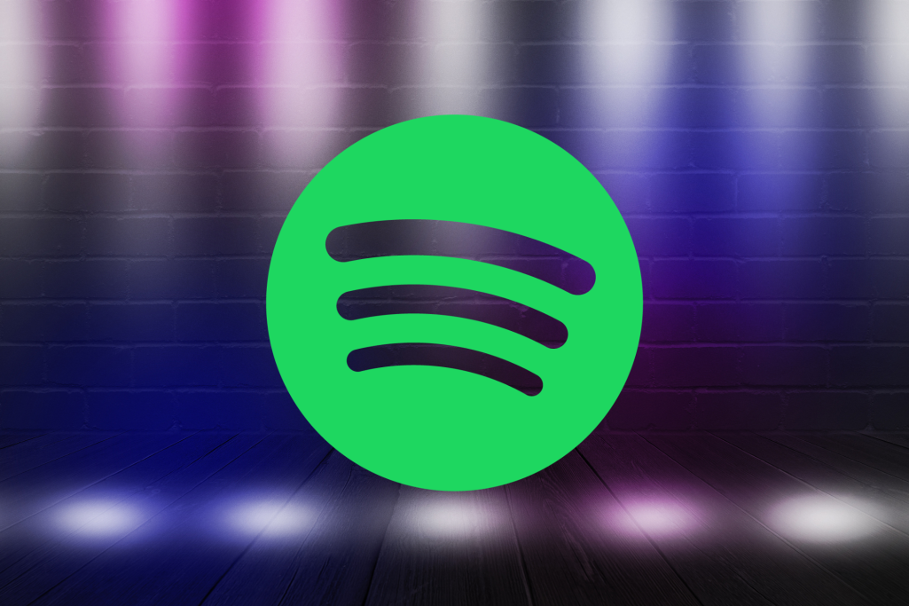 Spotify logo on a blurred background with purple and blue lights.