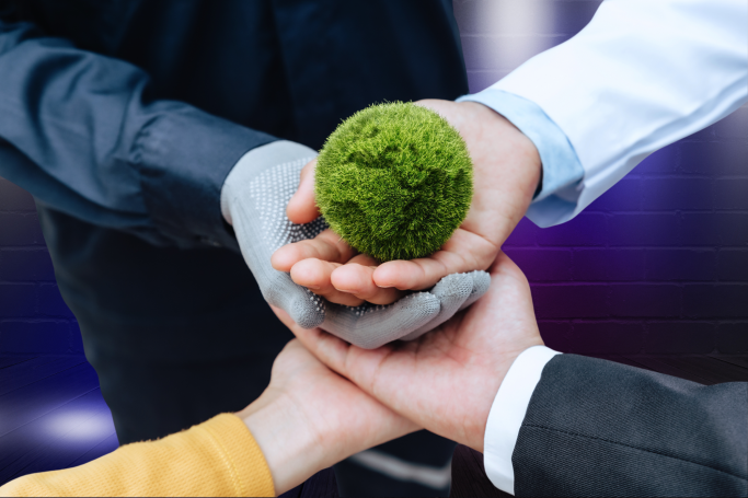 Hands of different colors holding a small green globe, symbolising environmental care.